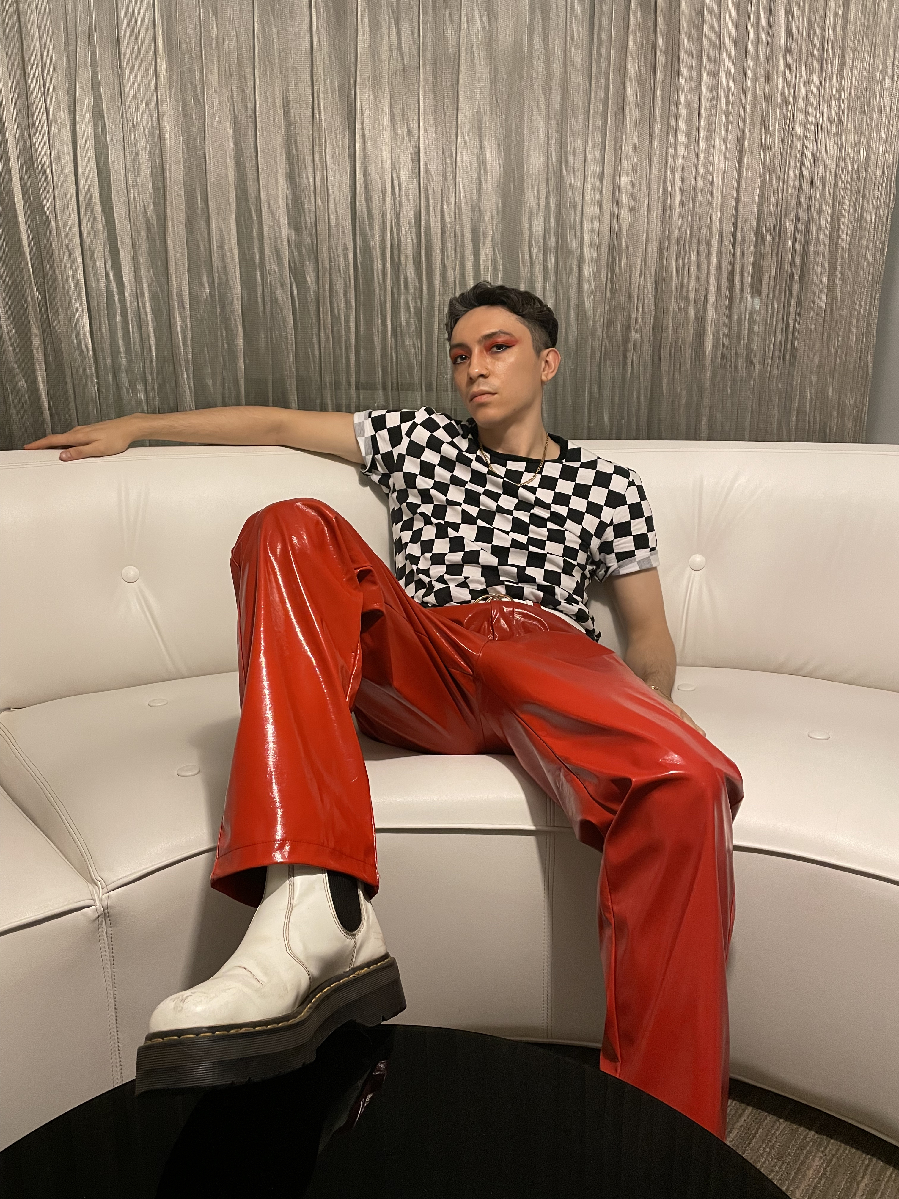 Stephen wearing red vinyl pants and black and white checkered top